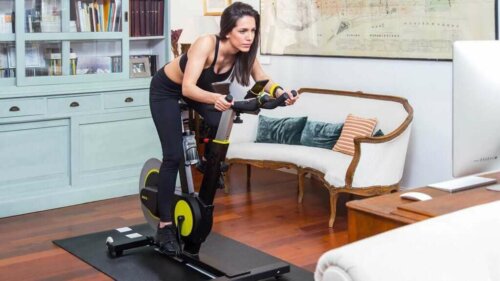 A woman cycling in her living room.