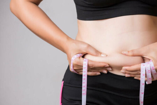Kvinde måler sit mavefedt og ønsker at nyde de sundhedsmæssige fordele ved gelatine i kosten, som blandt andet er til at opnå vægttab
