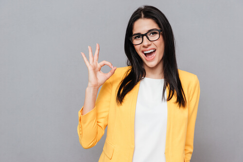 woman in yellow jacket making the OK symbol because colors influence emotions