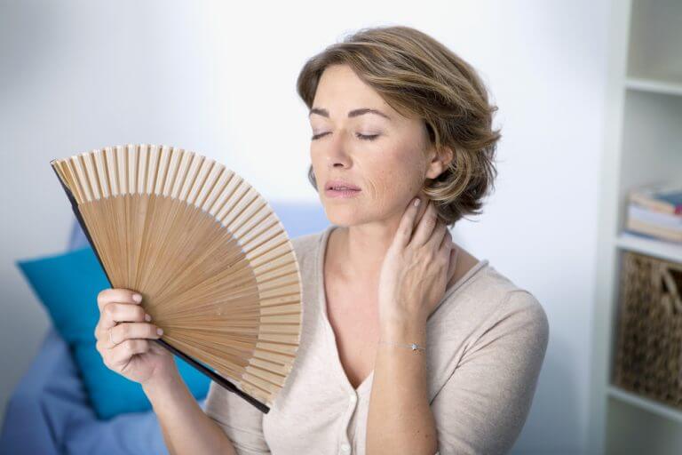 woman fanning herself indoors during menopause