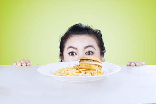 woman looking at a burger and fries...not good for mental balance