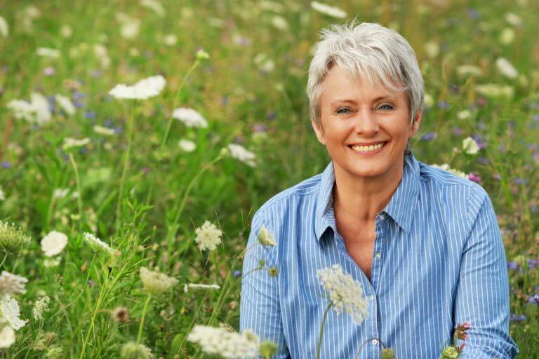 woman in a field of flowers finding happiness during menopause