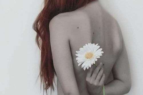 naked woman with long hair and flower