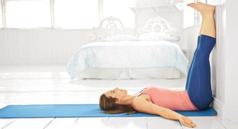 Woman doing yoga at home benefits of elevating your legs