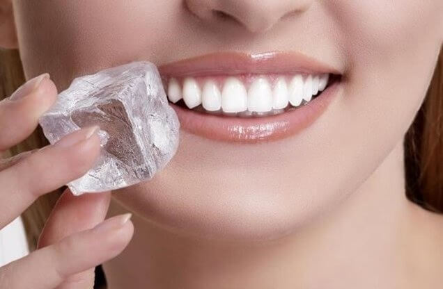 Woman applying ice on a canker sore.