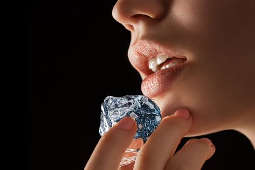 A woman applying ice for her canker sores.