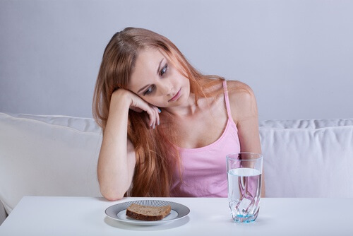 woman with loss of appetite looking at toast and water