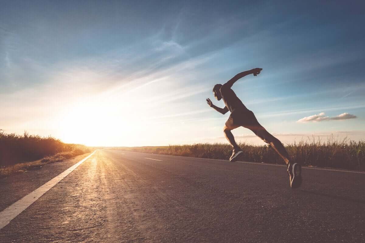 A man sprinting down a country road.