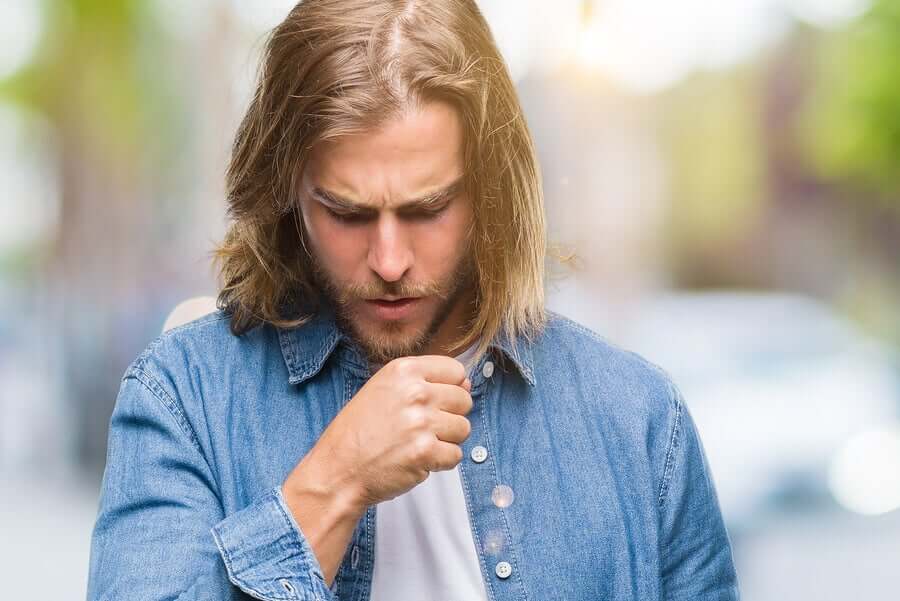 A man coughing into his hand.
