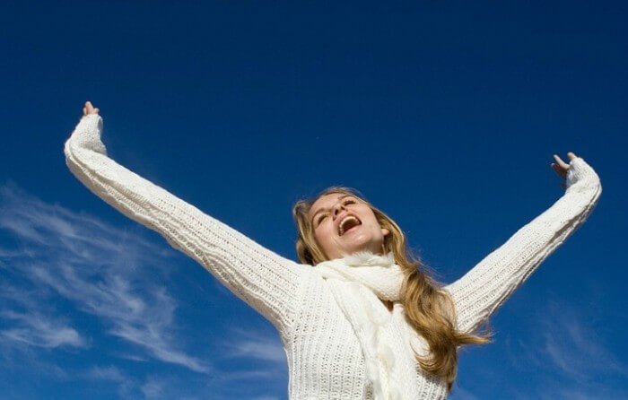 girl in white sweater celebrating healthy mental balance