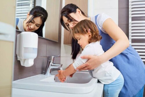 A mother washing her daughter's hands.