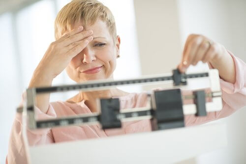 A woman weighing herself.