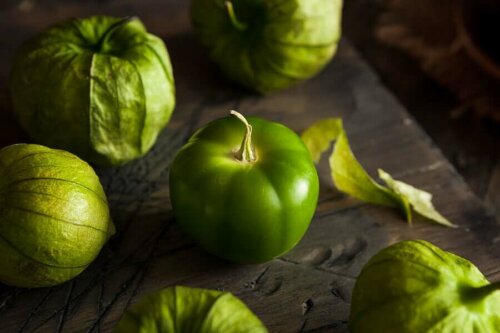 A naked tomatillo surrounded by properly dressed ones.