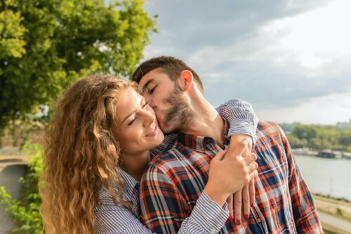 A woman hugging a man while he kisses her.