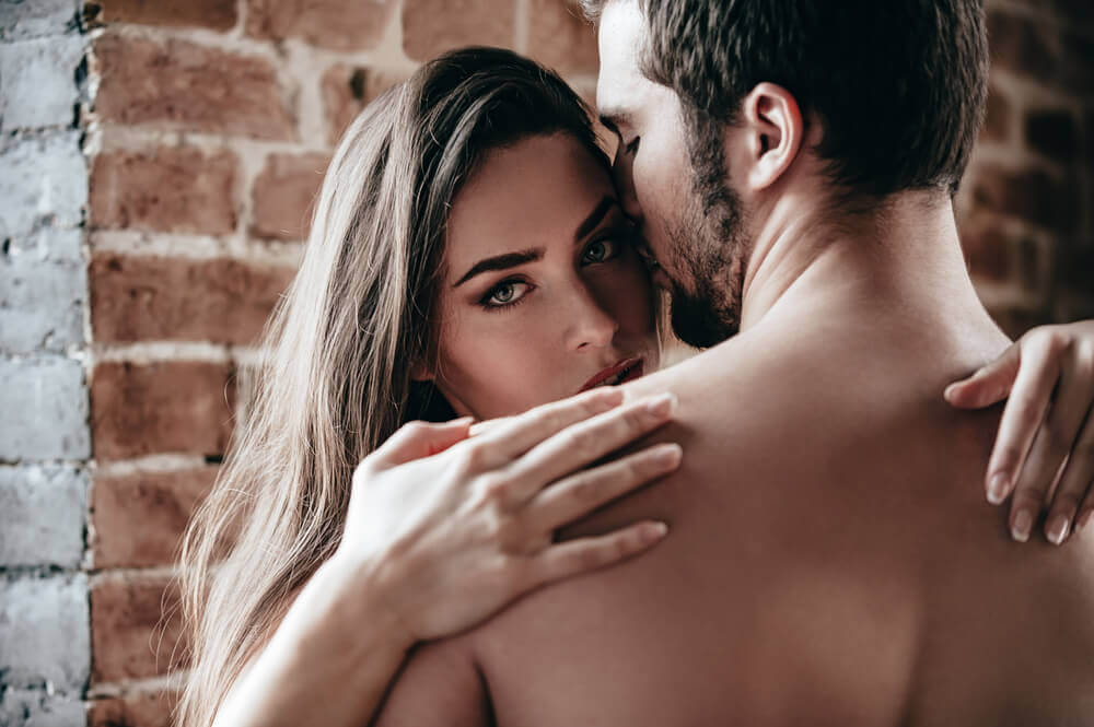 A couple having sex against a wall.