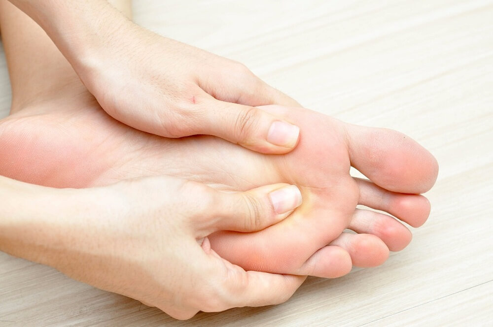 Person der trykker sig paa underfladen af foden - symptomer paa diabetes du ikke