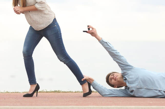 man holding a ring clinging onto a woman's leg