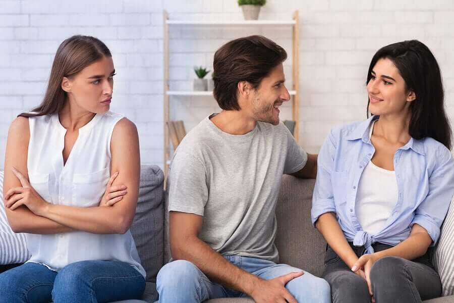 A man flirts with a girl while his partner looks on.