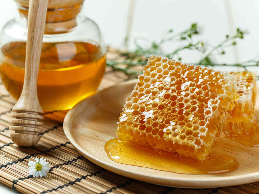 A jar of honey and a honeycomb.