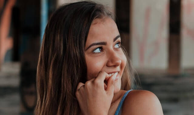 A girl smiles while looking up.