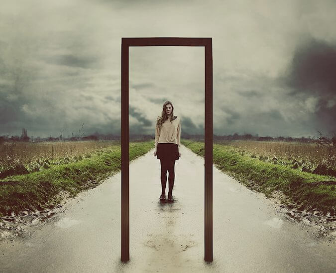 A girl facing a mirror on a road.