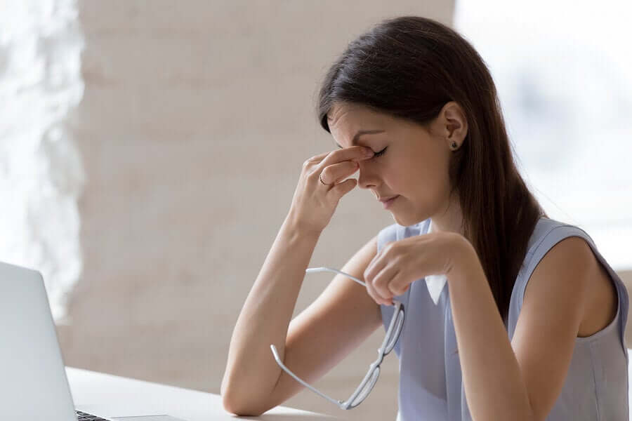 A woman in bed with a migraine.