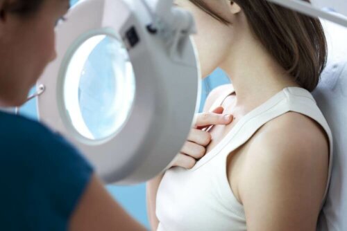 A doctor inspecting a wart on a patient.