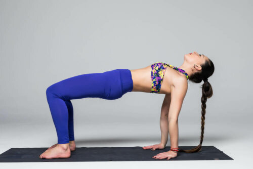 A woman in the bridge pose which is good for toning your legs.