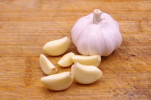 A knob of garlic besides some garlic cloves.