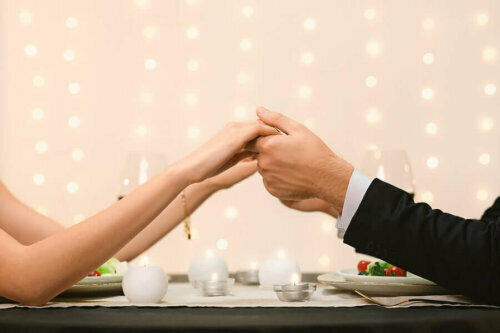 couple holding hands over a table