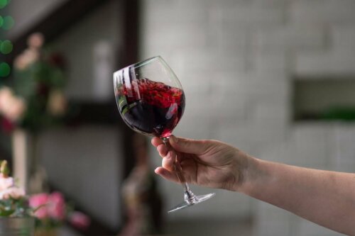 A person swishing a glass of wine around.