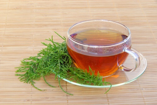 Cup of horsetail tea on a bamboo mat