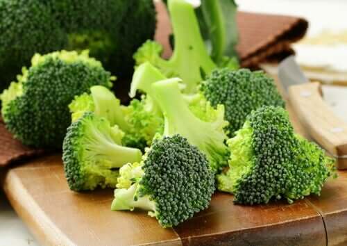 Broccoli florets on a wooden cutting board.