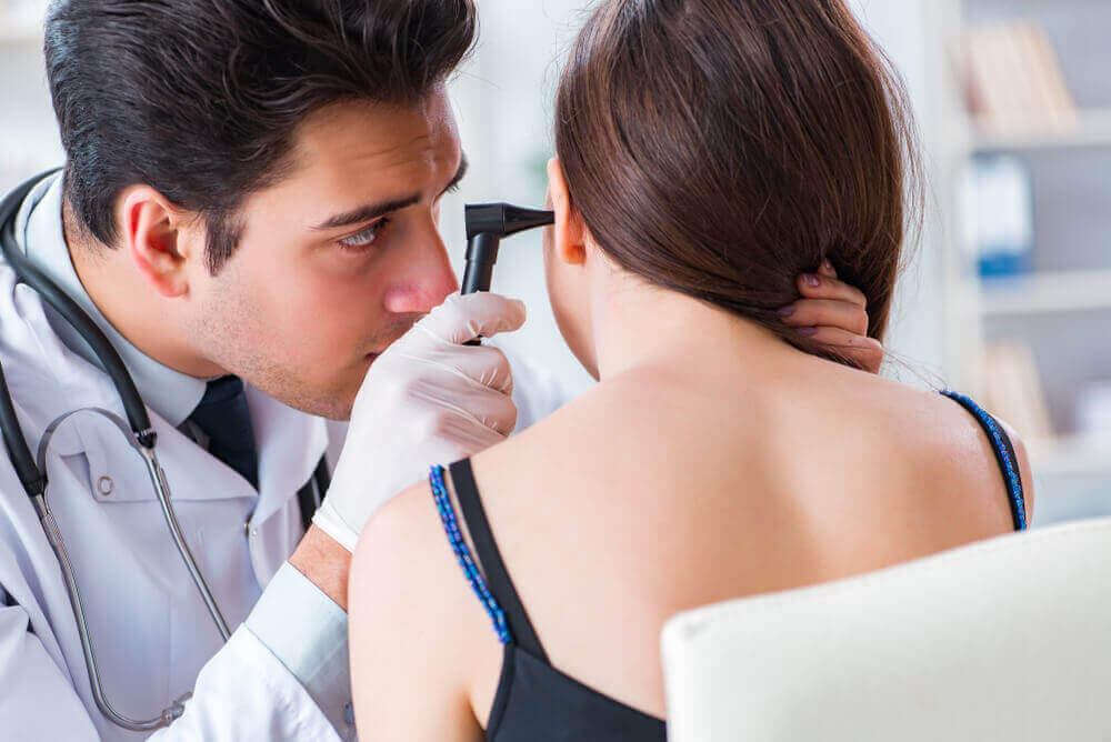 A doctor examining a woman's ear.