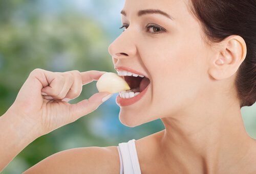 woman eating a garlic clove to help treat hypertension