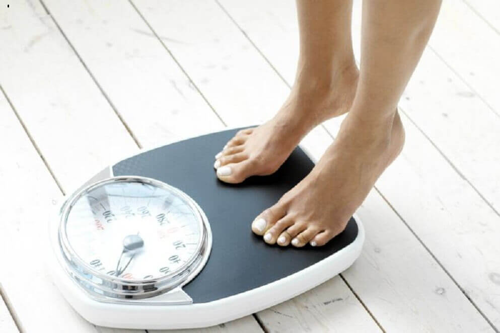 A woman weighing herself.