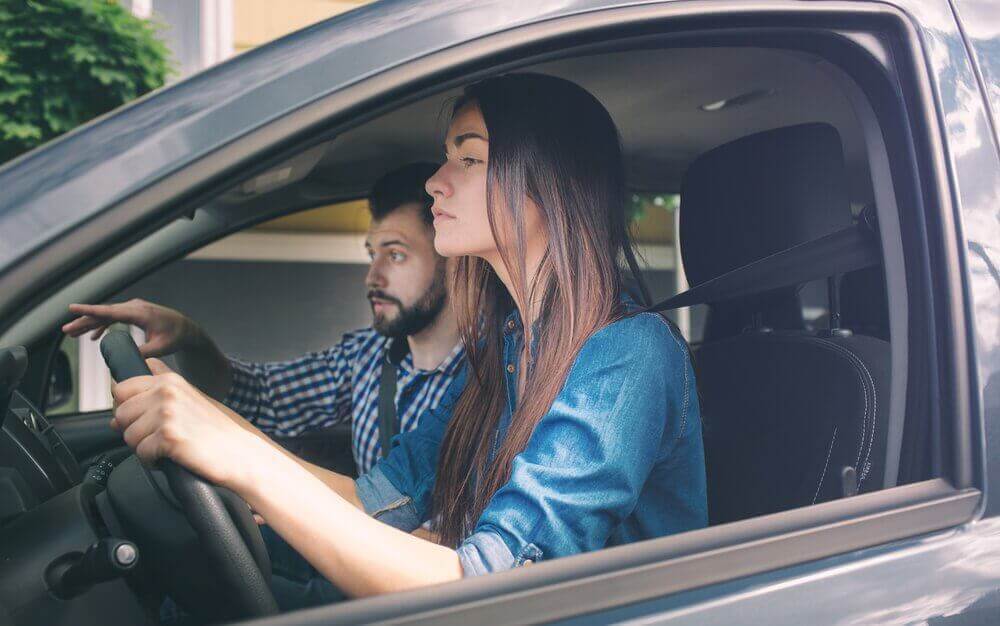 man teaching a woman how to drive and using positive affirmations 