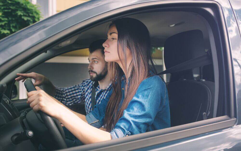 man teaching a woman how to drive and using positive affirmations