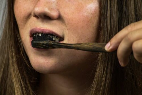 woman brushing her teeth with carbon