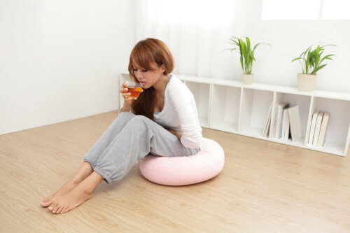 A woman drinking a cup of thyme tea.