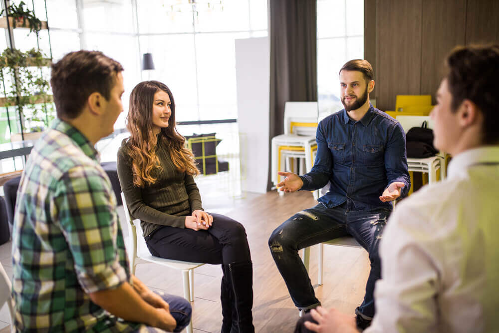 A group of people sitting interacting with each other in a healthy way