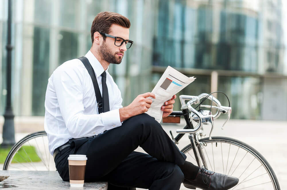 man with glasses reading a report