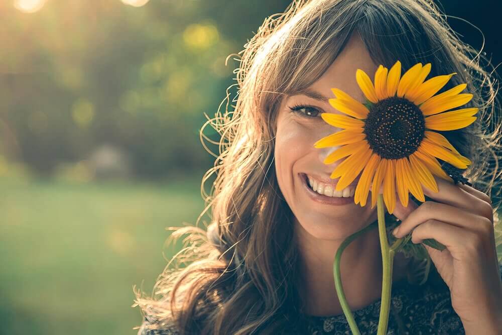 A happy woman and a sunflower.