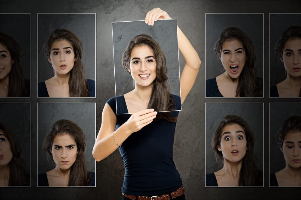 Woman with photos of many faces, each with a different emotion