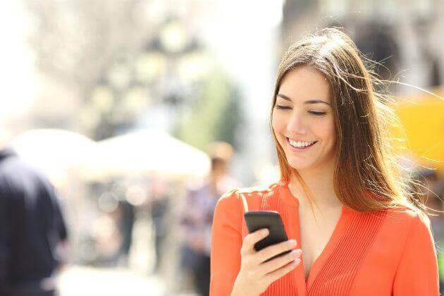 woman using her cell ohone and smiling
