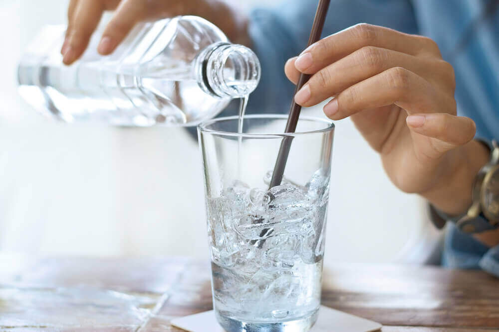 A woman serves a glass of water.