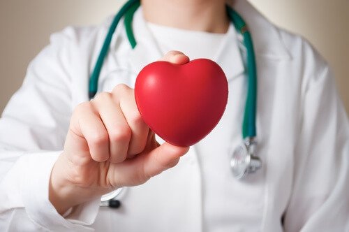A doctor holding a healthy heart from drinking aloe vera juice.