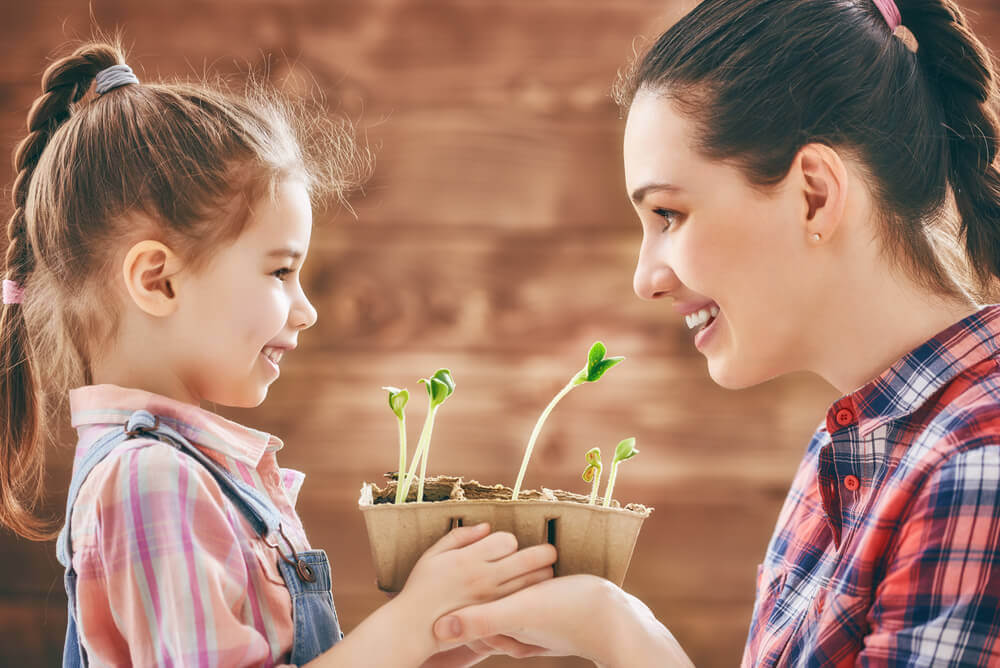 Mother planting flowers with daughter