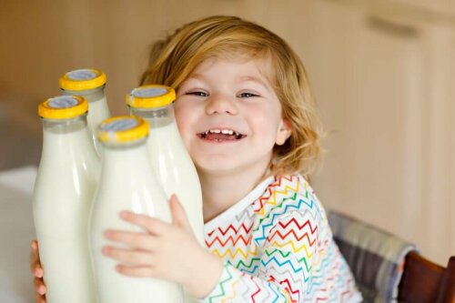 child hugging four bottles of milk smiling