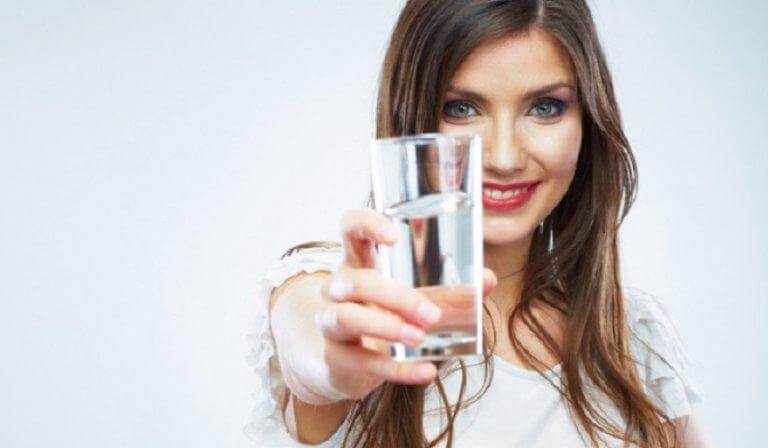 a woman holding a glass of water